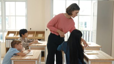 Sınıfta çeşitli çocuklar sınıf ödevlerini yaparken, Kafkasyalı öğretmen sınıfta yürüyor ve öğrenci ödevlerini kontrol ediyor. Çeşitli zeki öğrenciler ilkokulda ders veriyor ve not alıyor. Pedagoji.