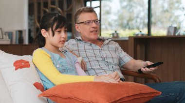 Grandfather and granddaughter together watch interesting entertainment media on TV. Old senior use technology communicate with young generation cross generation gap strengthen family bond. Divergence. clipart