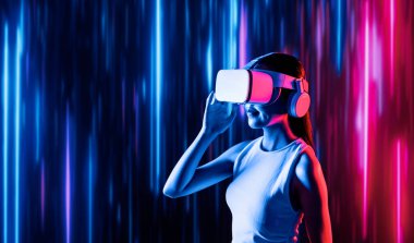 Zeki bir kadın, metaevreni birbirine bağlayan VR kulaklık takan neon ışıklarla çevrili duruyor. Gelecekteki siber uzay topluluğu teknolojisi. Uzaklara bakan zarif bir kadın ve tatmin edici bir şekilde gülümsüyor. Halüsinasyon.