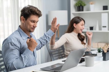 Gülümseyen mutlu iş arkadaşları beşlik çakıyor aynı zamanda yaratıcı proje planını yumrukluyor ve sabahları modern ofiste gündelik işlerde en yüksek kârı elde ediyorlar. Varsayım.