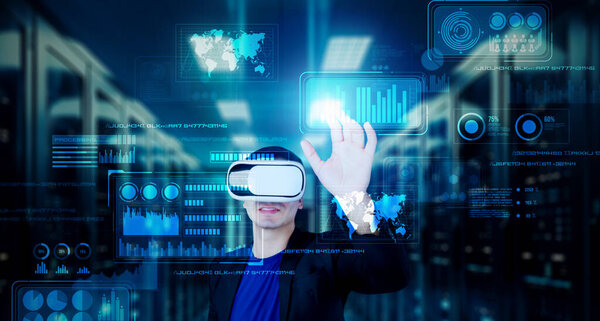 Бизнесмен с гарнитурой, стоящий в центре обработки данных при анализе финансовых данных. Менеджер, указывающий на голограмму статистики маркетинга и использующий очки дополненной реальности при принятии решения. Изобретательность.