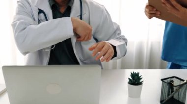 Hastane masasında birlikte çalışan ve tıbbi tedavi planlayan çeşitli profesyonel sağlık görevlileri. Takım çalışması başarılı hastalıklara ve hastalıklara yol açar. Ağır çekim. Katı.