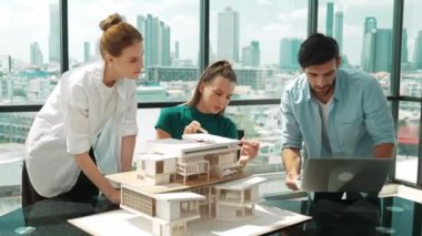 Akıllı mimar takımı ev tasarımı hakkında tartışırken yakışıklı erkek işçi dizüstü bilgisayar kullanarak fikir sunuyor. Profesyonel mühendis paylaşımı, beyin fırtınası tasarımı. İş tasarımı. İzleme