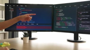 Yavaş çekim arkası yazılım geliştirici mühendisi bilgisayar programlama için birlikte çalışarak hata ayıklama kodunu çözüyor, ofiste monitörde karmaşık algoritmaları çözüyor. Filizlenen
