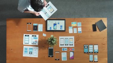 İş adamının toplantı odasında Ux Ui tasarımına bakması ve onu seçmesi. Yetenekli geliştirici yaratıcı iş yerinde cep telefonu arayüzü ya da yazılım uygulaması tasarlıyor ve planlıyor. Cemaat.