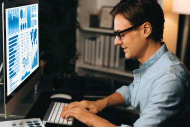 Akıllı iş adamı iş paragrafı dinamik pazarlama analizi planını analiz ediyor. Kağıt kağıtları ve bilgisayar monitörü raporlarını gece evdeki belge verileriyle karşılaştırmak için hazırlıyor. Bireysel.