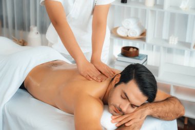 Kafkas erkek müşteri stres önleyici spa masajının keyfini çıkarıyor ve lüks otel veya oteldeki gündüz açık hava ortamında güzellik derisi eğlencesi ile şımartıyor. Sessiz.