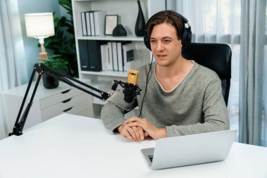 Sunucu kanalı, gülümseyen akıllı yayıncı kaydı, senaryosu ve akıllı telefonuyla sosyal medyada sohbet programı, kulaklık takarak modern ev stüdyosundaki video flamalarını kaydediyor. Bireysel.