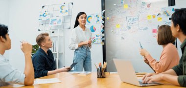 Genç ve güzel lider pazarlama stratejisini sunarken, uzman yatırımcı ve proje yöneticisi de yeni başlayan iş toplantısında iş performansını analiz etmeye çalışıyor. Çok ırklı bir grup. Tertemiz..