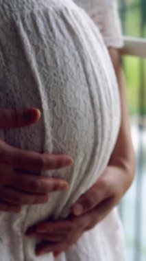 Hamile bir kadın çocuğuna bakarken kendini mutlu hissediyor. Hamile karnında bebek taşıyan hamile bir anne. Doğum öncesi bakım ve kadın hamileliği konsepti.