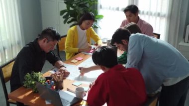 Top view of smart business team working together drawing mind map. Group of diverse people sharing marketing campaign or brainstorming idea and sharing plan by using colorful sticky notes. Convocation