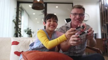 Büyükbaba ve torun birlikte konsol oyunu, eğlence medyası oynuyorlar. Eski kullanım teknolojisi yeni nesil ile iletişim kurar. Nesiller arası uçurum aile bağını güçlendirir. Uyumsuzluk.