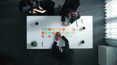 Kahve fincanı tutan zeki bir iş adamı masada otururken masaya yapışkan notlarla oturmuş. Yetenekli iş adamları tartışmaya ve pazarlama fikrini paylaşmaya başladılar. Müdürlük.