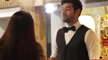 Yakışıklı, güler yüzlü bir barmen arkadaş, VIP müşterilerine içki listesi öneriyor. İçki tezgahı lüks, profesyonel barmen kostümü içinde harika bir ilk izlenim bırakıyor. Vinosity.