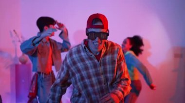 Çekici dansçı hip hop müzik eşliğinde çeşitli arkadaşlarıyla dans ediyor ve performansını destekliyor. Stüdyoda neon ışıklı şık kıyafetler giyen profesyonel çok kültürlü insanlar. Mutluluk.
