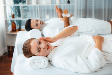 Kaplıca salonunun sakin, modern gündüz atmosferi, birkaç müşteri yüz maskesi takarak kendini yenilemeye çalışıyor. Yüz bakımı ve güzellik kozmetolojisi prosedürü. Sessiz.