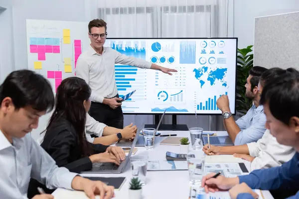 Ofiste sunum ya da analist ekibiyle toplantı odasında mali verileri analiz etmek için BI Fintech 'i kullanmak. İş adamları stratejik planlama için TV ekranında BI gösterge panelini inceliyor.