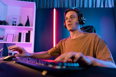 Kazanmak için çevrimiçi oyun oynayan akıllı flama makinesinin sunucu kanalı, neon ışıklı odada seçilen takım yarışması için izleyicilerle birlikte canlı yayında canlı yayında kulaklık takıyor. Bireysel.