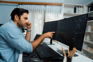 Akıllı IT geliştirici yöneticisi, bilgisayar ekranındaki yazılım kodlama sistemindeki sorunu çözen iş arkadaşına seslenerek modern ofiste uygulama programı güncellemesi yapıyor. Tahmin et..