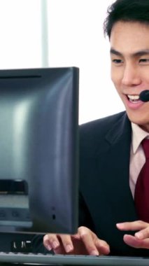 Ofiste çalışan kulaklık takan işadamları uzak müşteri ya da meslektaşlarını desteklemek için çalışıyorlar. Arama merkezi, tele pazarlama, müşteri destek acentesi telefon görüşmesinde hizmet sunar.