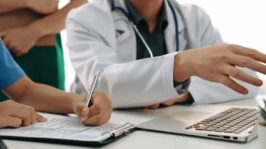 Hasta için hastane masasında çalışan ve tıbbi tedavi planlayanlardan oluşan profesyonel bir ekip. Takım çalışması başarılı hastalıklara ve hastalıklara yol açar. Ağır çekim. Katı.