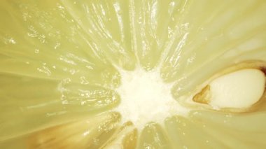 Bir limonun içine yakın çekim. Et kireç soluk sarı-yeşil bir renktir, kabuğun yanında daha koyu yeşil alanlar vardır. Canlı narenciye detaylarının büyüleyici keşfi. Limon dilimi. Geliştirilebilir.