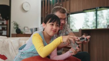 Büyükbaba ve torun birlikte konsol oyunu, eğlence medyası oynuyorlar. Eski kullanım teknolojisi yeni nesil ile iletişim kurar. Nesiller arası uçurum aile bağını güçlendirir. Uyumsuzluk.