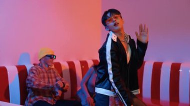 Asyalı bir adam pop müzikle dans ederken, çok kültürlü bir arkadaş evde ışık altında oturuyor. Çekici bir sokak dansçısı kameraya bakarken hip hop müzik dinliyor. Mutluluk.