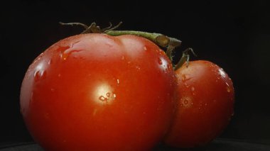 Macrography, tomatoes nestled within a rustic wooden basket are showcased against a dramatic black background. Each close-up shot captures the rich colors and textures of the tomatoes. Comestible. clipart