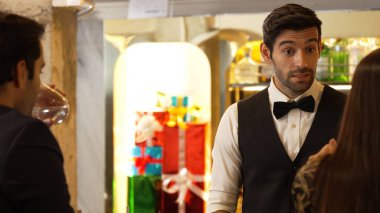 Zeki, gülümseyen barmen lüks bir barda buzlu içecekler hazırlarken aynı zamanda canlı, aydınlık atmosfer barında ve restoranda VIP müşterilerle canlı sohbetler yapıyor. Vinosity.