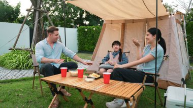 Family all together sit at camp in garden with tasty snack. Lovely parent use outdoor camping activity as way to communicate and spending time with young generation cross generation gap. Divergence. clipart