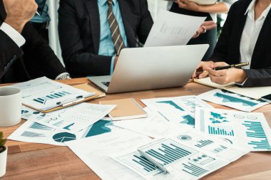 Ofis masasındaki finansal veri raporlarını analiz eden çeşitli bir grup iş analisti. Stratejik pazarlama planlaması için iş istihbarat analizine göre grafikler ve grafikler.