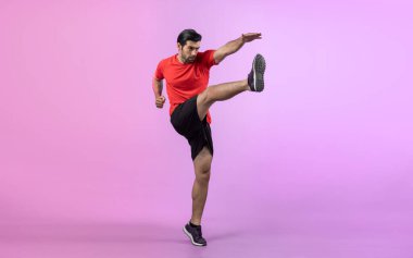 Vücut uzunluğunun tamamı atletik ve sporcu genç bir adamın kardiyo egzersizinde, izole edilmiş arka planda tekme pozisyonunda. Sağlıklı aktif ve vücut bakımı yaşam tarzı.