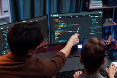 Akıllı bilişim geliştiricisi bilgisayar ekranındaki çevrimiçi web sitesinde kodlama programı uygulamasına bakıyor, ofisteki iş pazarlamasında akıllı veritabanı geliştirme sistemini analiz ediyor. İnfobahn.