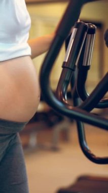 Yoga odasındaki spor salonunda aktif hamile kadın egzersizi. Hamile karnında bebek taşıyan hamile bir anne. Doğum öncesi bakım ve kadın hamileliği konsepti.