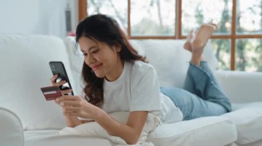 Kadın alışverişi ya da internet pazarında online ödeme modern yaşam tarzı için satılık eşyalar arıyor ve canlı siber güvenlik yazılımı tarafından korunan cüzdandan çevrimiçi ödeme için kredi kartı kullanıyor