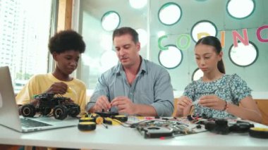 Yetenekli öğretmen çeşitli öğrencilere kablo ve elektronik ekipman kullanarak araba modelini tamir etmeyi öğretiyor. Bilgisayara bakarken ana kartı kontrol etmek için elektrikli alet kullanmayı öğrenen bir kız. Öğretim
