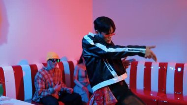 Asyalı bir adam pop müzikle dans ederken, çok kültürlü bir arkadaş evde ışık altında oturuyor. Çekici bir sokak dansçısı kameraya bakarken hip hop müzik dinliyor. Mutluluk.