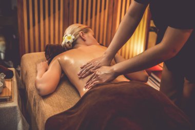 Beyaz kadın müşteri stres önleyici spa masajının keyfini çıkarıyor ve lüks otel ya da otelde sıcak mum ışığında güzellik teniyle eğleniyor. Sessiz.