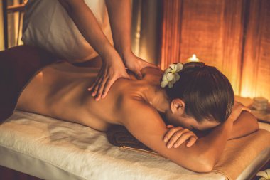 Beyaz kadın müşteri stres önleyici spa masajının keyfini çıkarıyor ve lüks otel ya da otelde sıcak mum ışığında güzellik teniyle eğleniyor. Sessiz.