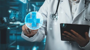 Tıbbi haçı işaret ederken ve laboratuvarda geçmişi bulanık dururken, elinde tablet bulunan yetenekli doktorlara yakın çekim yapın. Tıbbi çalışanlar tıbbi verileri analiz edip bağlantı kuruyor. İyileştirici.