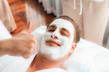 Kaplıca salonunun sakin atmosferi, insan müşterisi modern gün ışığında lüks yüz kremi masajıyla kendini yenileme zevkine kapılıyor. Yüz bakımı ve güzellik konsepti. Sessiz.