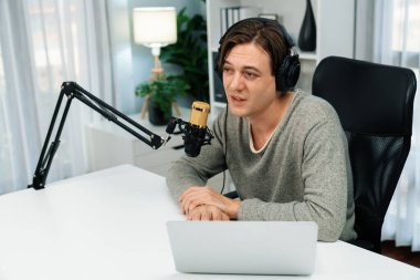 Sunucu kanalı, gülümseyen akıllı yayıncı kaydı, senaryosu ve akıllı telefonuyla sosyal medyada sohbet programı, kulaklık takarak modern ev stüdyosundaki video flamalarını kaydediyor. Bireysel.