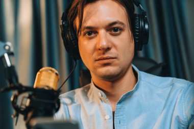 Sunucu kanalı akıllı yayıncı canlı sosyal medyada kamera önünde yüz portresi yapıyor. Etkilenen yayıncı, modern ofis stüdyosunda kulaklık takıyor. Bireysel.