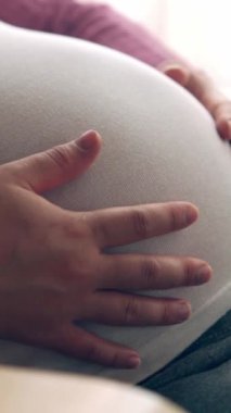 Hamile bir kadın çocuğuna bakarken kendini mutlu hissediyor. Hamile karnında bebek taşıyan hamile bir anne. Doğum öncesi bakım ve kadın hamileliği konsepti.