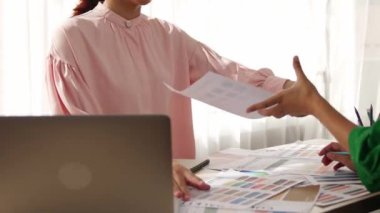 Yavaş çekim iki tasarımcı beyin fırtınası yapıyor ve grafik tasarımı için renk seçiyor ya da istemci renk bozukluklarını tasarımcı bürosundaki kromatik konsültasyonla karşılaştırıyor. Değiştirilmiş