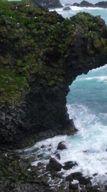 İzlanda, Arnarstapi 'nin Atlantik kıyısındaki inanılmaz taş kemer Gatklettur bazalt kayası. Ünlü doğal yaşam formu İzlanda 'nın batısını ziyaret etmek için turistleri cezbediyor..