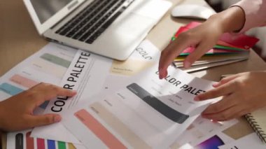 Grafik tasarımı için renk seçimi yapan ve beyin fırtınası yapan iki tasarımcının yavaş çekim çekimi ya da tasarım bürosunda kromatik danışmanlık hizmeti isteyen bir müşteri. Değiştirilmiş