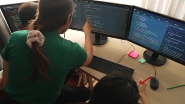 Yavaş çekim arkası yazılım geliştirici mühendisi bilgisayar programlama için birlikte çalışarak hata ayıklama kodunu çözüyor, ofiste monitörde karmaşık algoritmaları çözüyor. Filizlenen