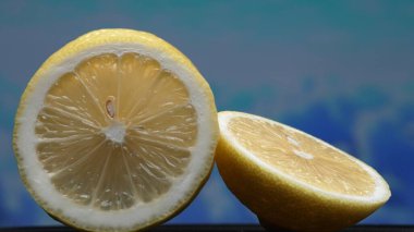 A slice of fresh lemon, bright yellow and vibrantly citric, lies exposed. The flesh, glistening with refreshing juice, reveals its segmented interior. The essence of citrus vibrancy. Comestible. clipart